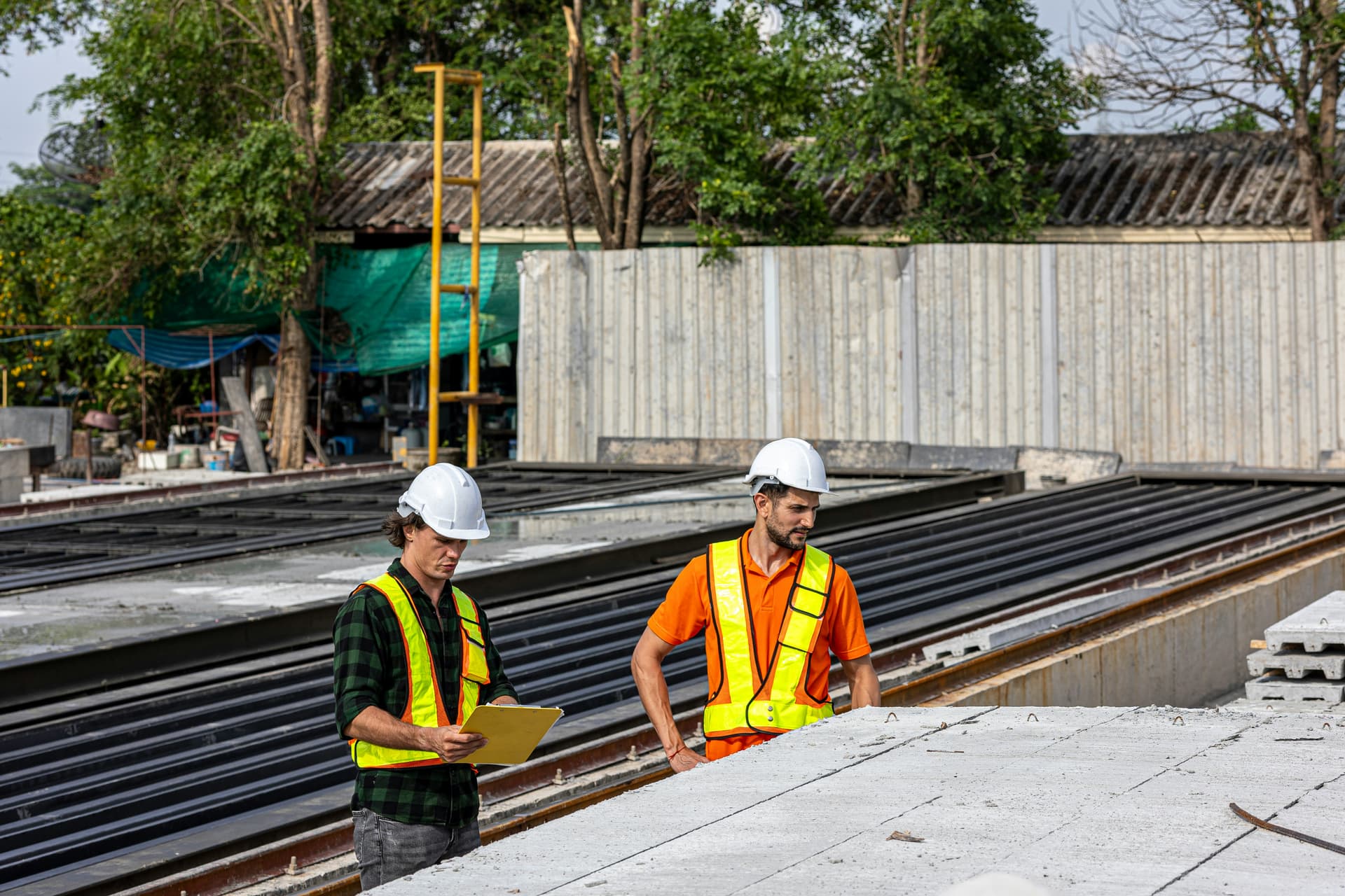 Engineer inspecting industrial automation equipment with a tablet.